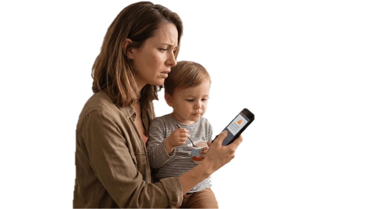 Una mamma e il suo bambino ricevono sul telefono un avviso CiboSicuro sul richiamo di uno yogurt, prima di mangiarlo